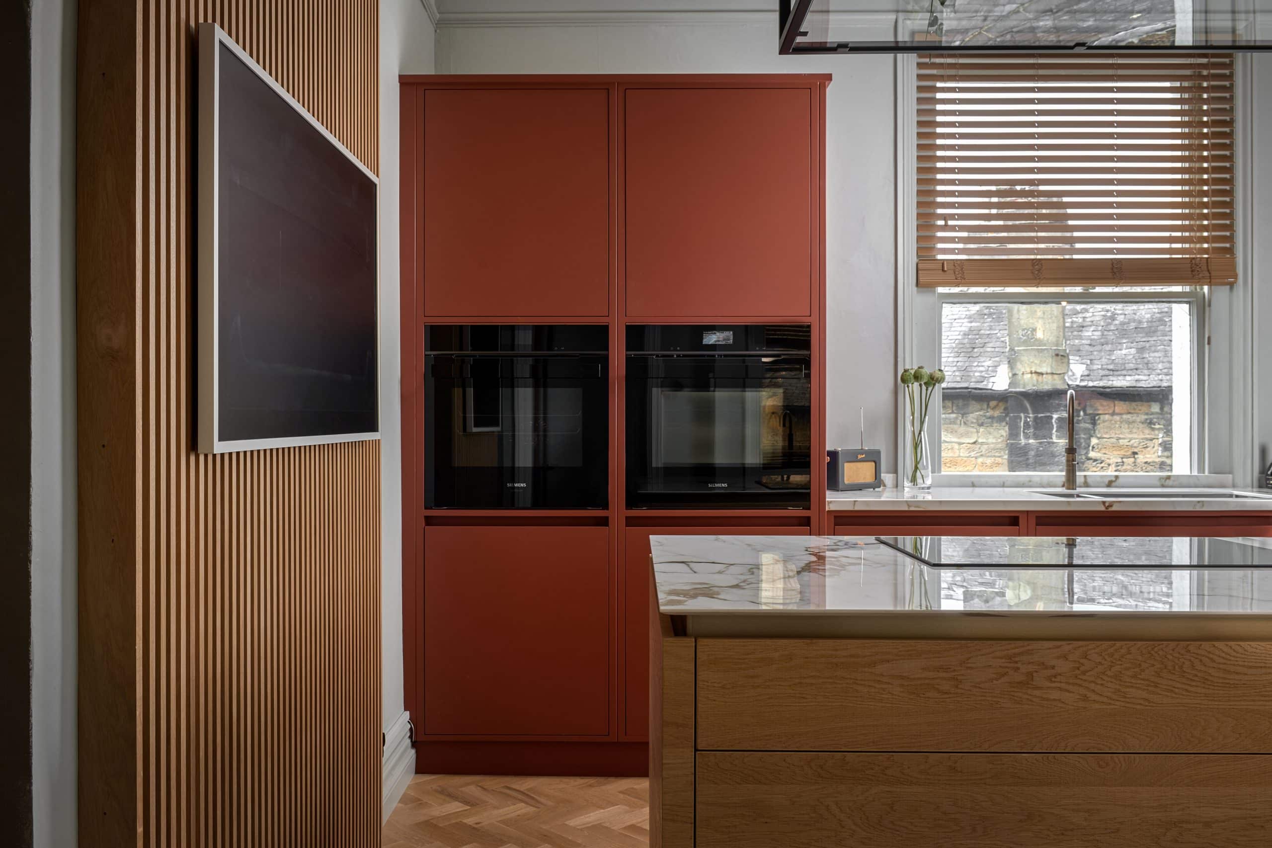 Benjamin Moore Orange Painted Kitchen with wood slatted panelling and Kitchen island.